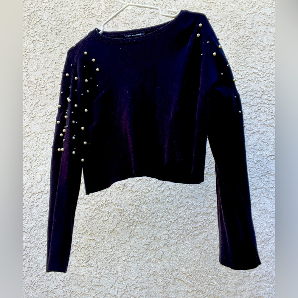 Black long sleeve sweater with pearl accessories on the shoulders